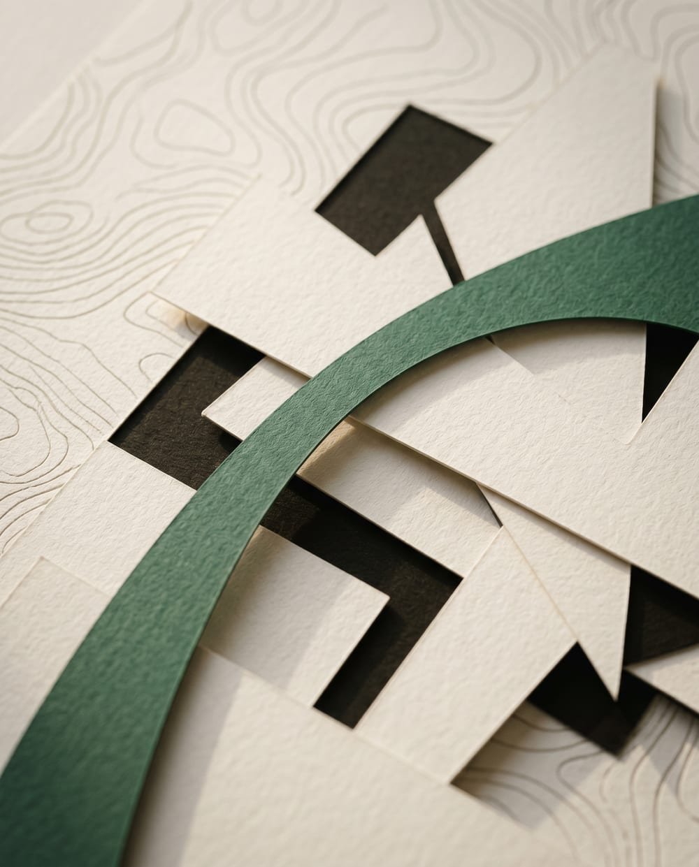 Layered cream and ink paper shapes with a green accent curve — a composition in progress